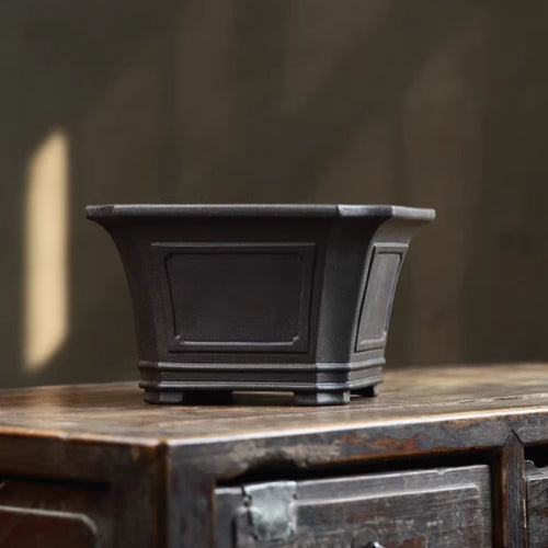 Dark square bonsai pot with flared rim, framed panels and banded base