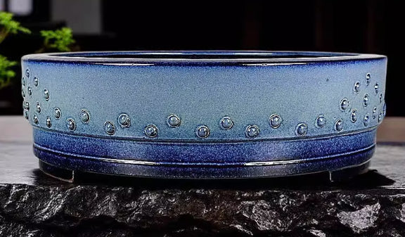 Close side view of the blue drum pot's studs and dark lower band