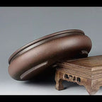 Angled brown round pot showing its rolled rim and low foot ring