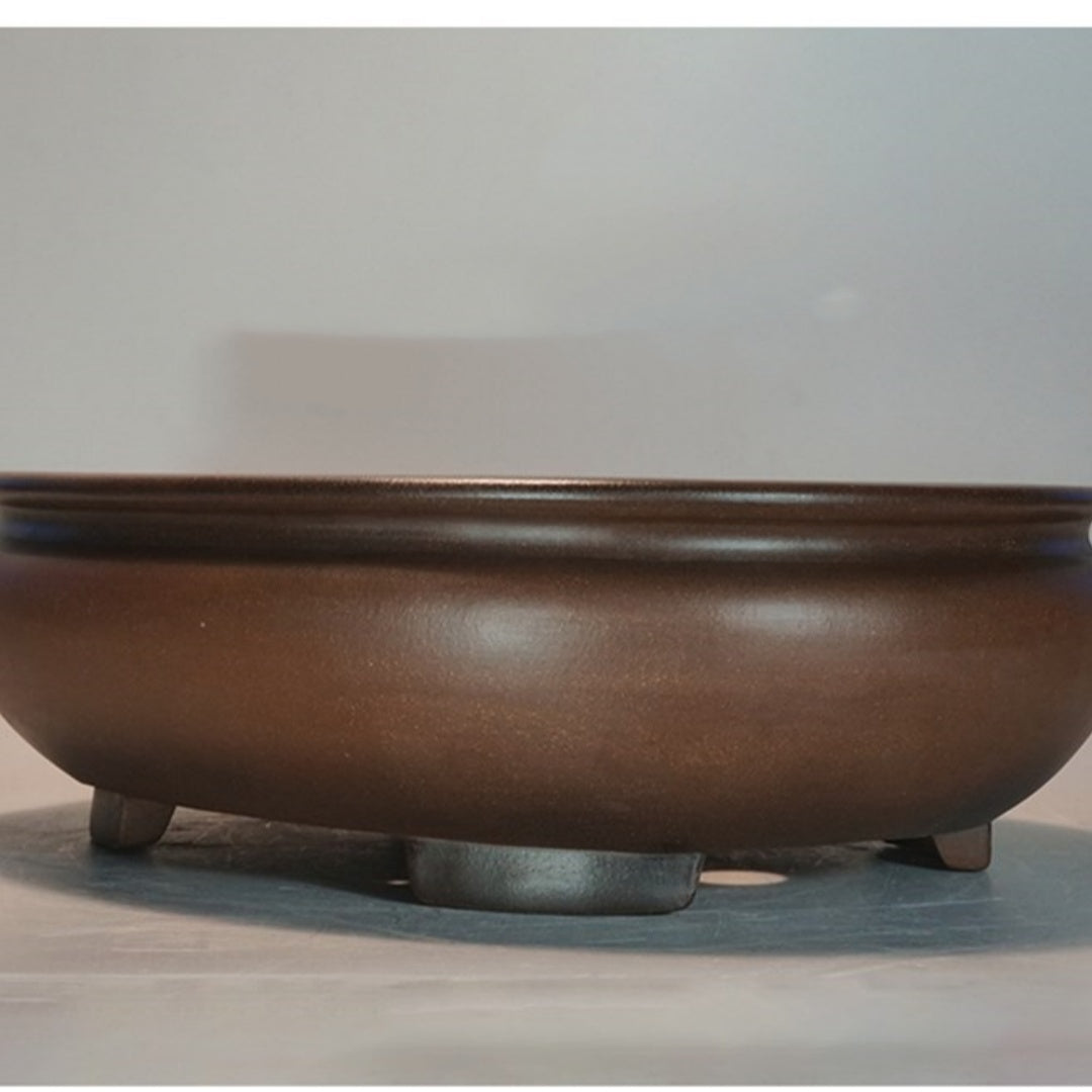 Close front view of the oval brown bonsai pot's body and feet
