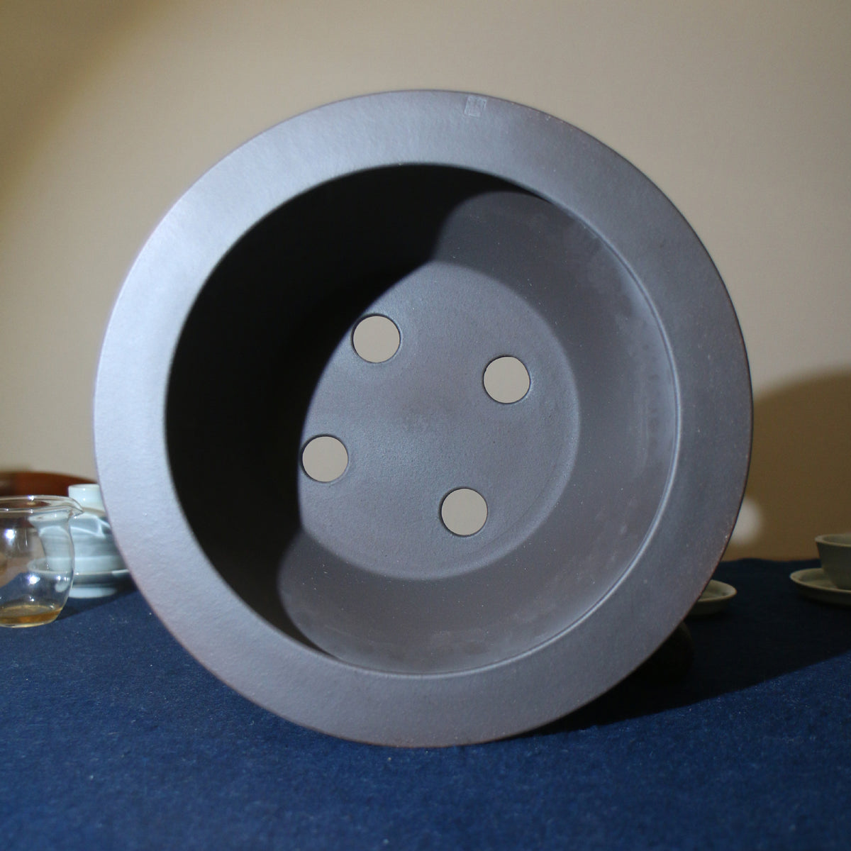 Top view of the dark round pot with four drainage openings