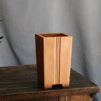 Angled tall ochre square pot showing open rim and vertical grooves