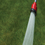 Red watering head spraying a broad shower onto a lawn