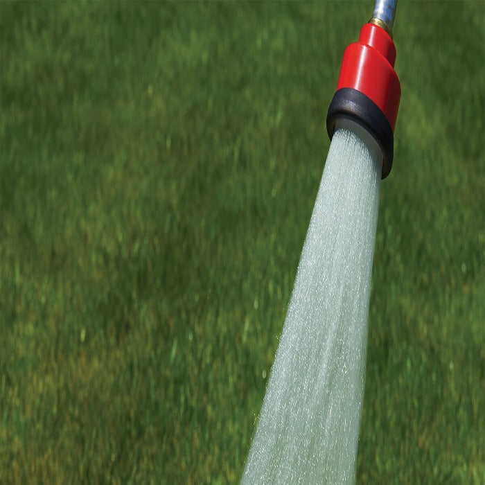 Red watering head spraying a broad shower onto a lawn