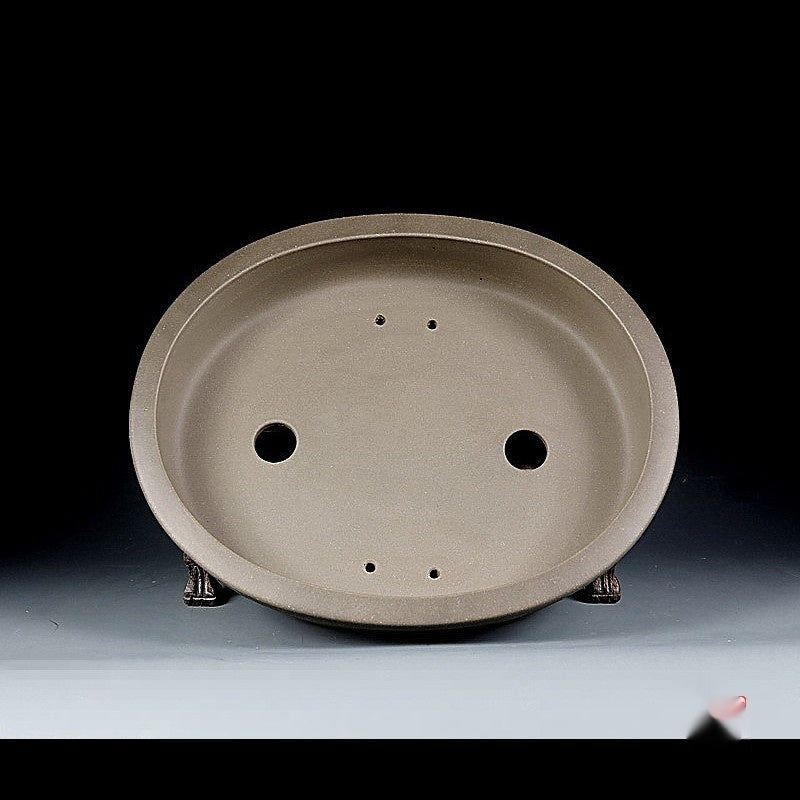 Interior of the taupe oval pot with two drainage holes and four smaller openings