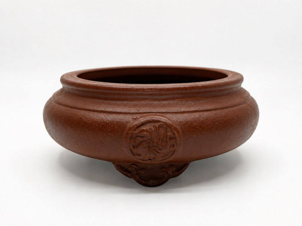 Brown round bonsai pot with rounded walls, raised circular ornament and decorative feet