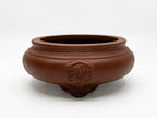 Brown round bonsai pot with rounded walls, raised circular ornament and decorative feet