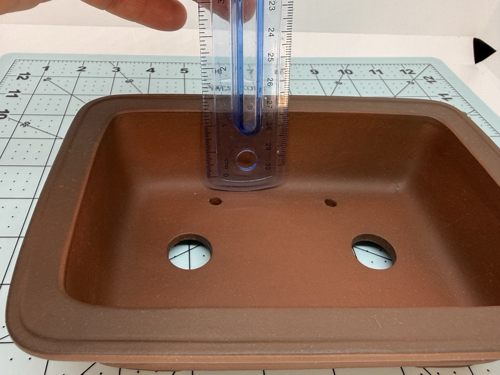 Ruler inside the brown rectangular pot demonstrating its usable depth