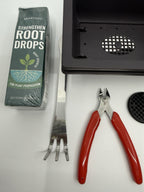 Close-up of Root Drops packaging, black training pot, red-handled cutters, rake and mesh disc