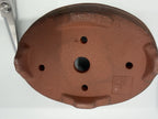 Underside of the starter kit's brown oval pot showing one central drainage hole and four smaller openings