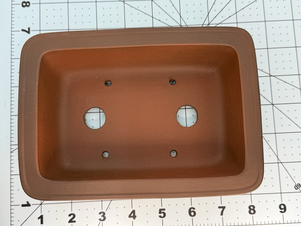 Top view of the brown rectangular pot showing two drainage holes and four smaller openings