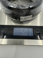 Close-up of wrapped black wire coils on a digital scale with the display visible