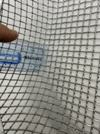 Close-up of finer square sieve mesh beside a ruler