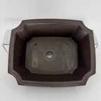 Top view of the dark rectangular pot showing one central drainage hole and four smaller openings
