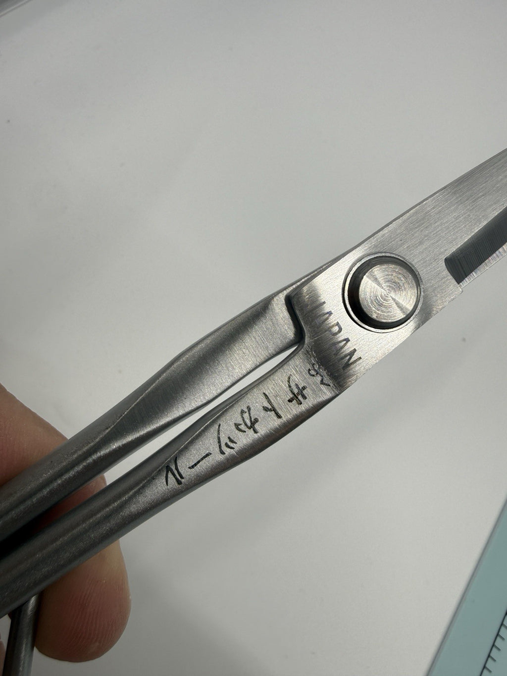 Close-up of the scissors' pivot screw and engraved markings, including JAPAN