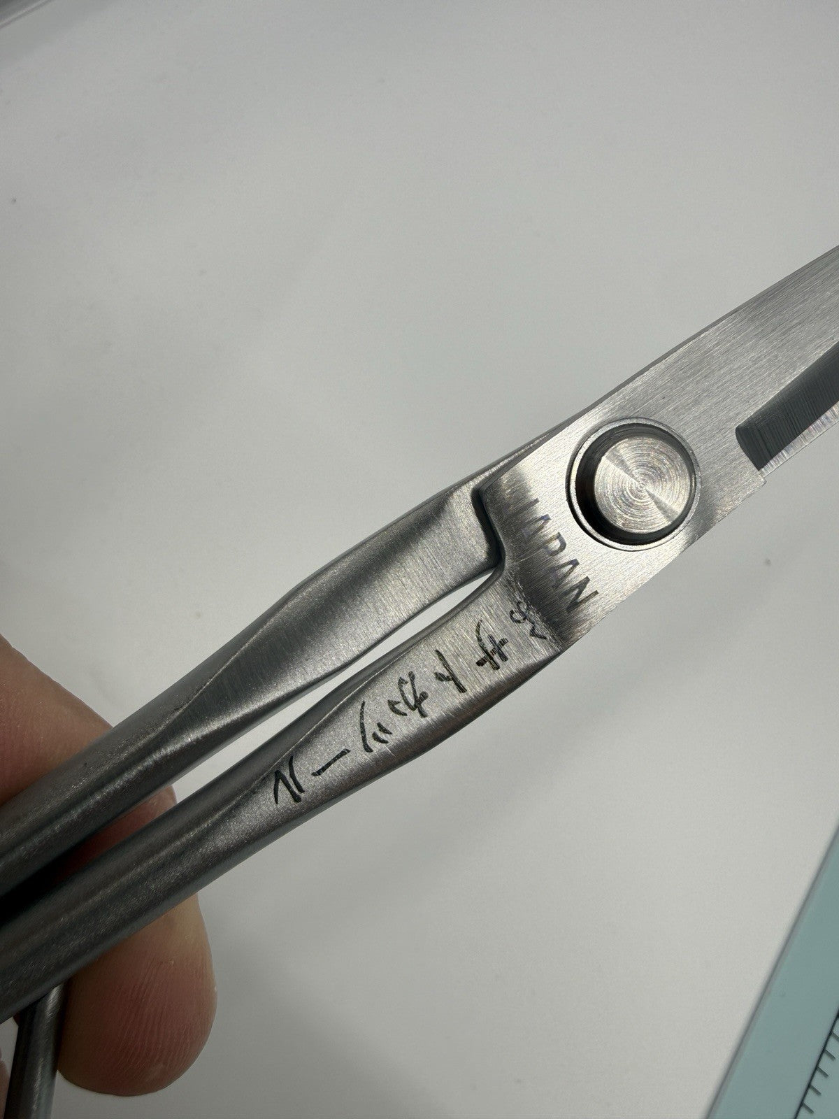Close-up of the scissors' pivot screw and engraved markings, including JAPAN