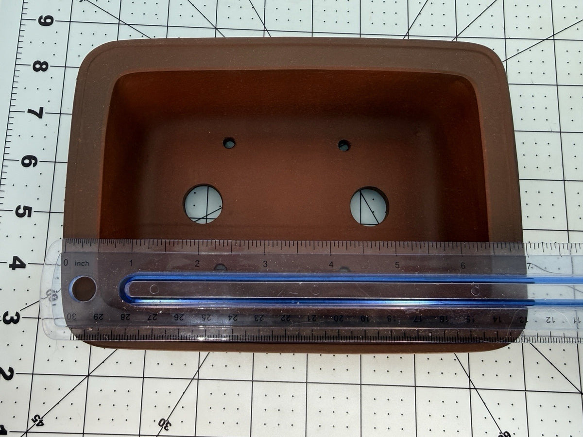 Ruler spanning the brown rectangular pot's interior opening