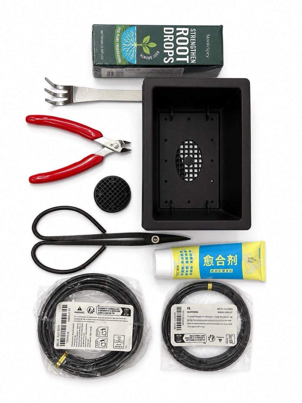 Bonsai starter kit with black rectangular training pot, scissors, red-handled cutters, rake, wire and packaged supplies