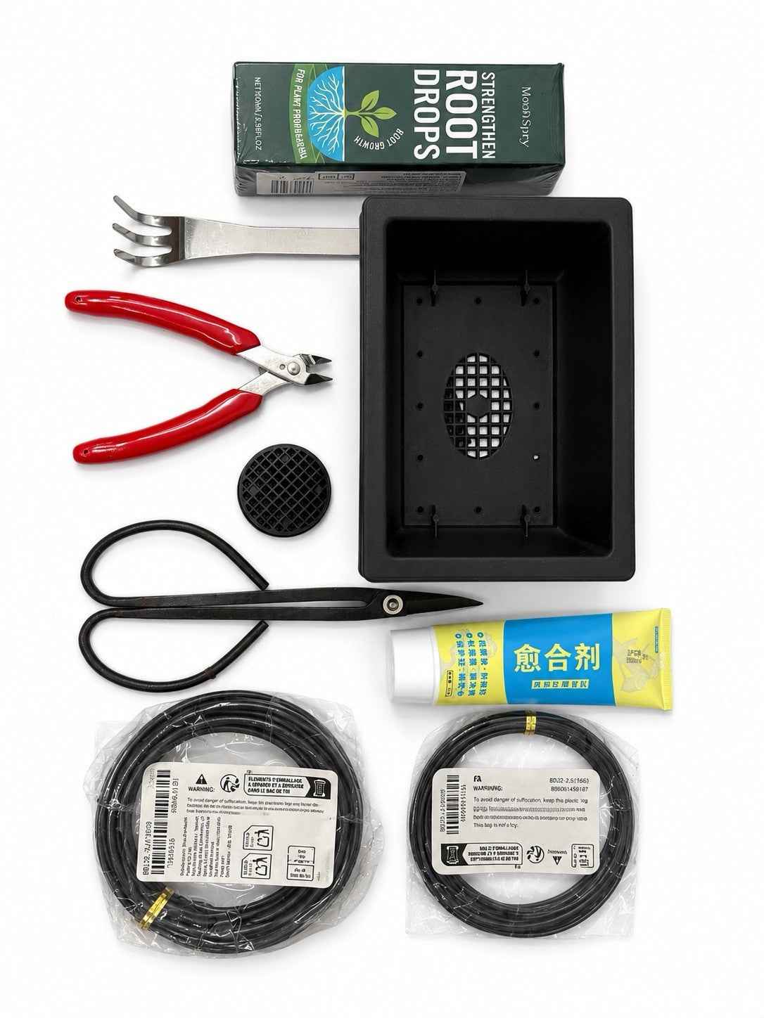 Bonsai starter kit with black rectangular training pot, scissors, red-handled cutters, rake, wire and packaged supplies