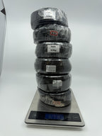 Six black wire coils stacked vertically on a digital kitchen scale