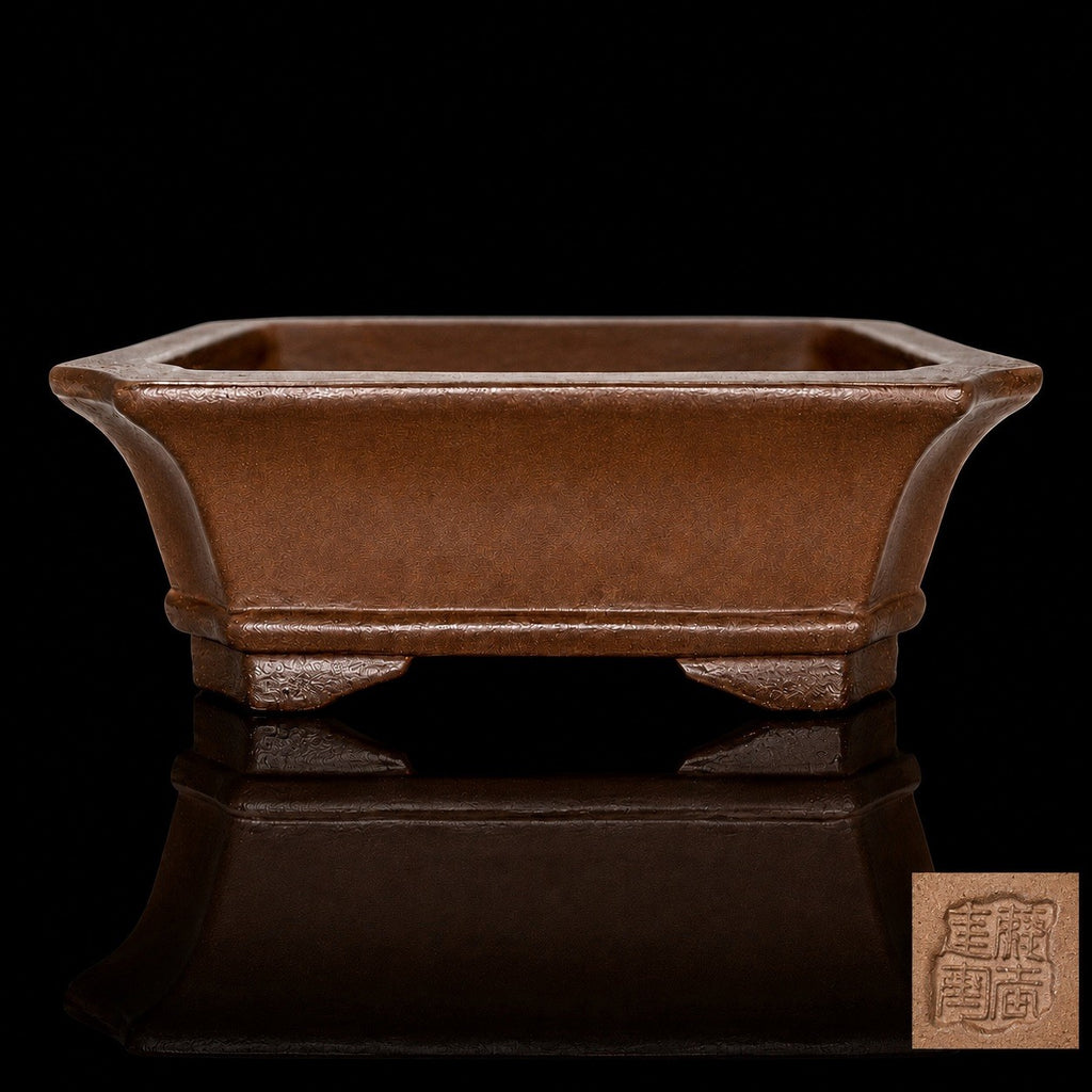 Brown rectangular bonsai pot on a reflective black surface, with an inset showing its impressed seal