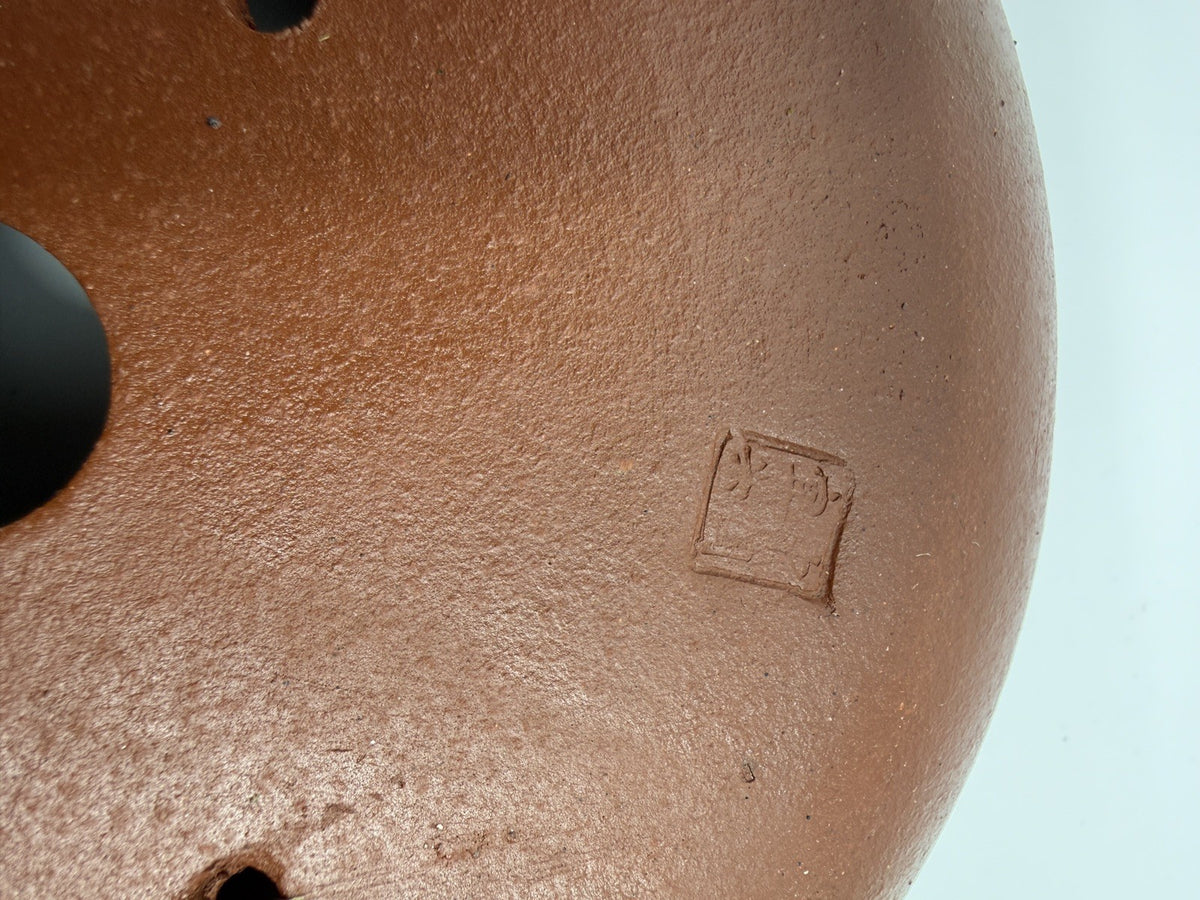 Close-up of the impressed square mark in the brown pot's base