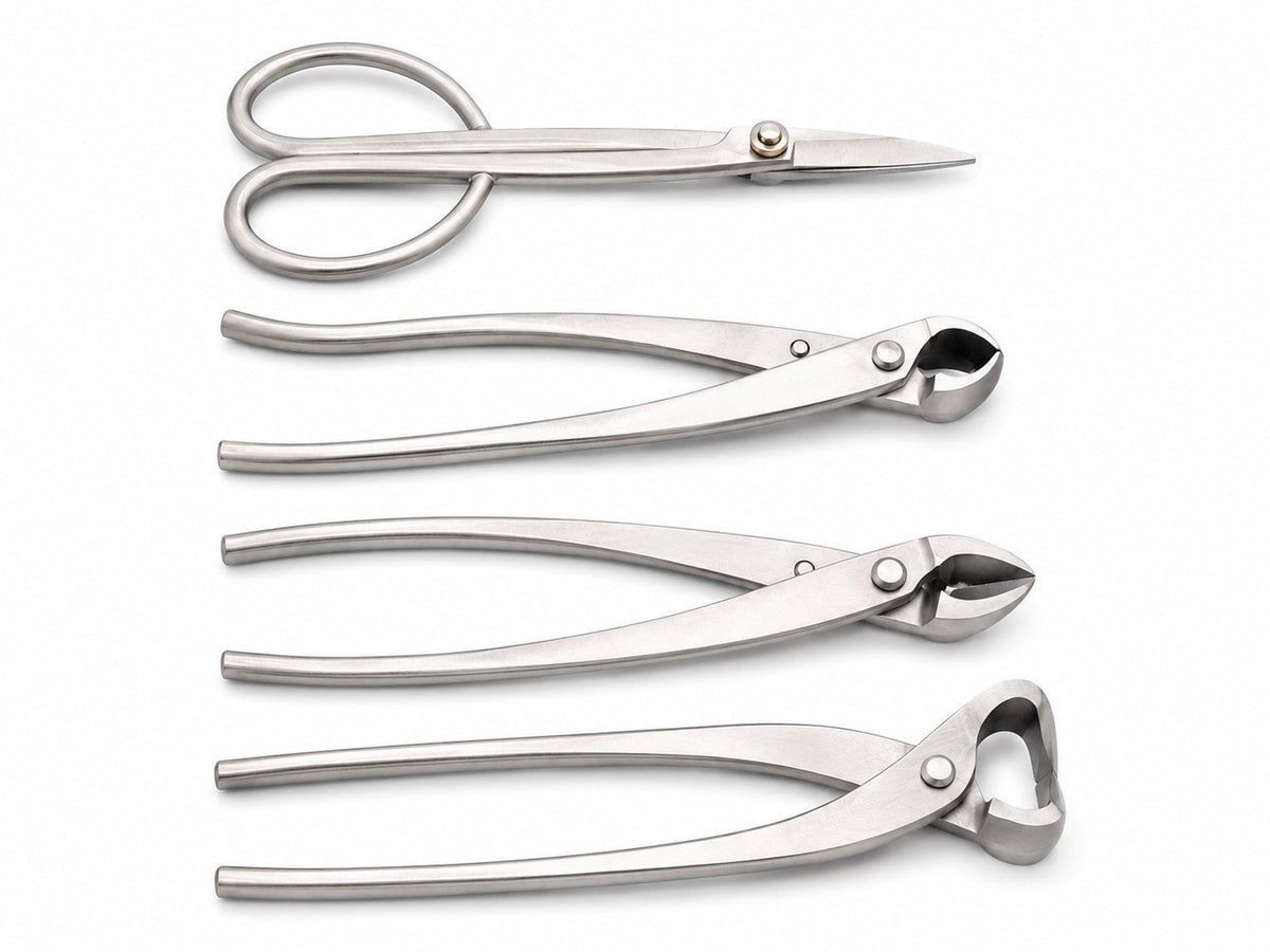 Four silver-colored bonsai tools arranged on white: scissors and three long-handled cutters