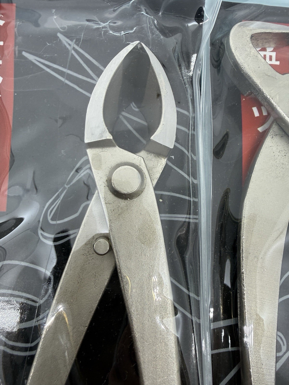 Close-up of a packaged bonsai cutter with pointed curved jaws