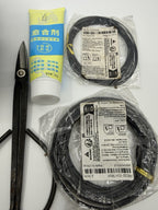 Close-up of black scissors, a yellow-labeled tube and two packaged wire coils