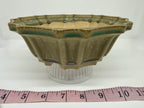 Angled view of the fluted green pot above a tape measure