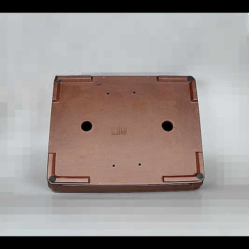 Underside of brown rectangular bonsai pot showing feet and two large openings