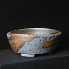 Angled round pot showing irregular rim and textured charcoal patches