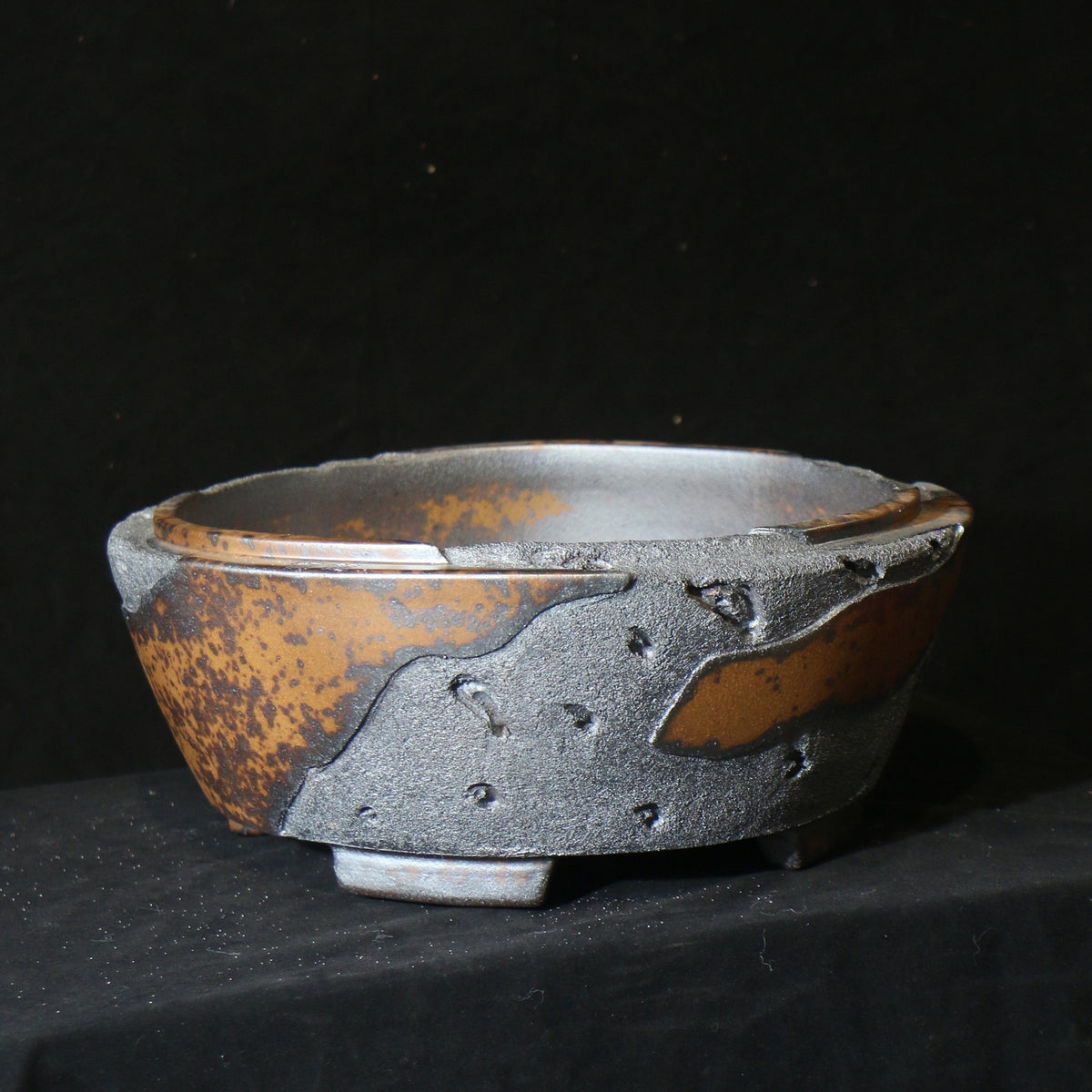 Angled round pot showing irregular rim and textured charcoal patches