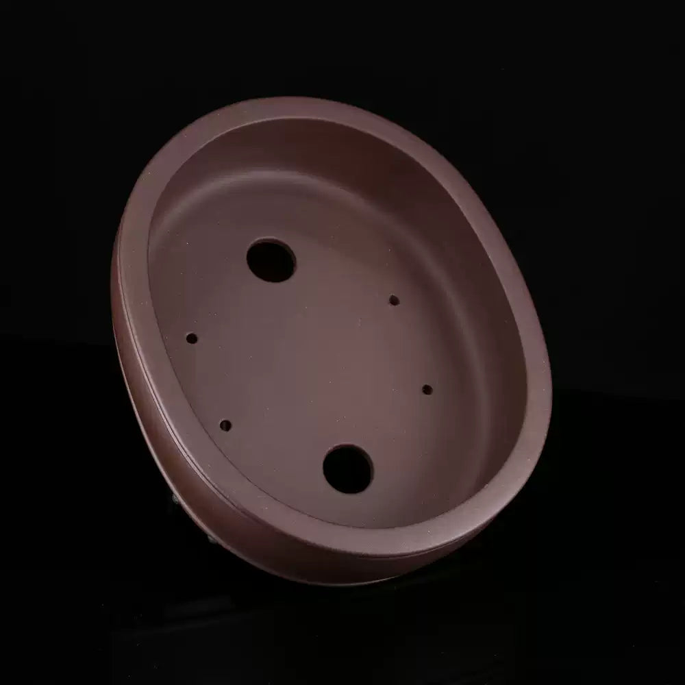 Top view of brown oval pot showing two large openings and smaller holes