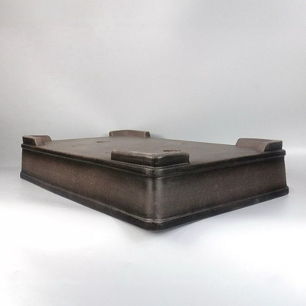 Underside angle showing the rectangular pot's raised feet and banded lower wall
