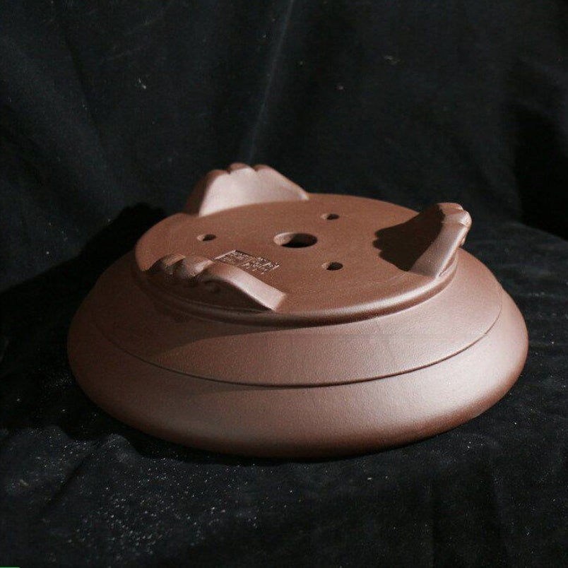 Drainage and wiring holes beneath round cloud-foot pot