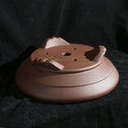 Drainage and wiring holes beneath round cloud-foot pot