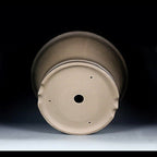 Underside angle of the taupe pot showing central drainage and small holes