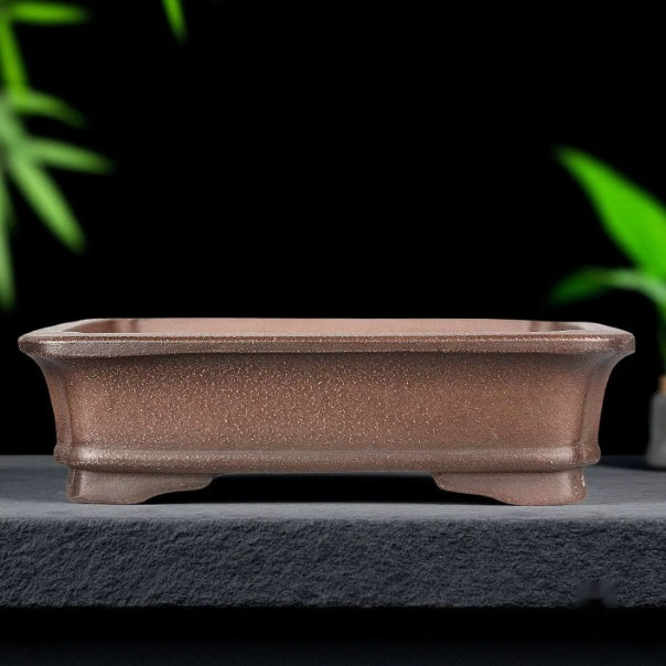 Brown rectangular pot with flared rim and low shaped feet