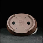 Underside of the oval pot showing drainage holes and impressed marks