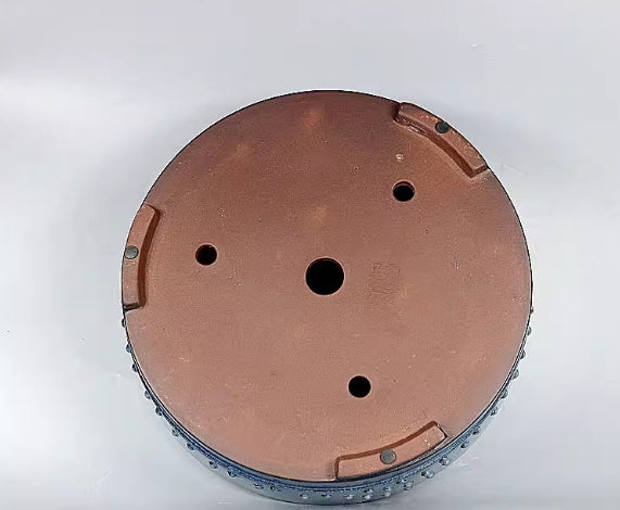 Underside of the blue pot showing bare brown clay and four drainage openings