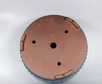 Underside of the blue pot showing bare brown clay and four drainage openings