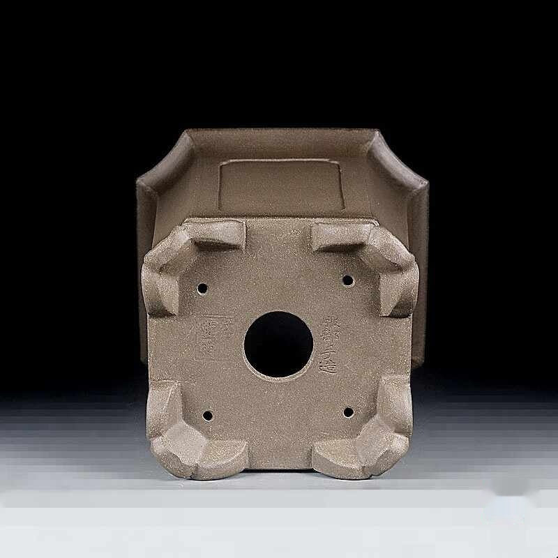 Underside of the tall square pot showing central drainage hole and corner feet