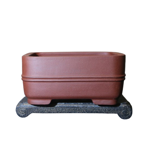 Isolated red-brown rectangular pot with double band on a stand