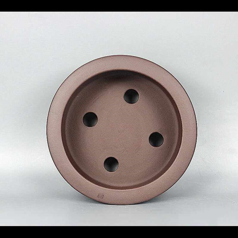 Round pot interior showing four drainage openings