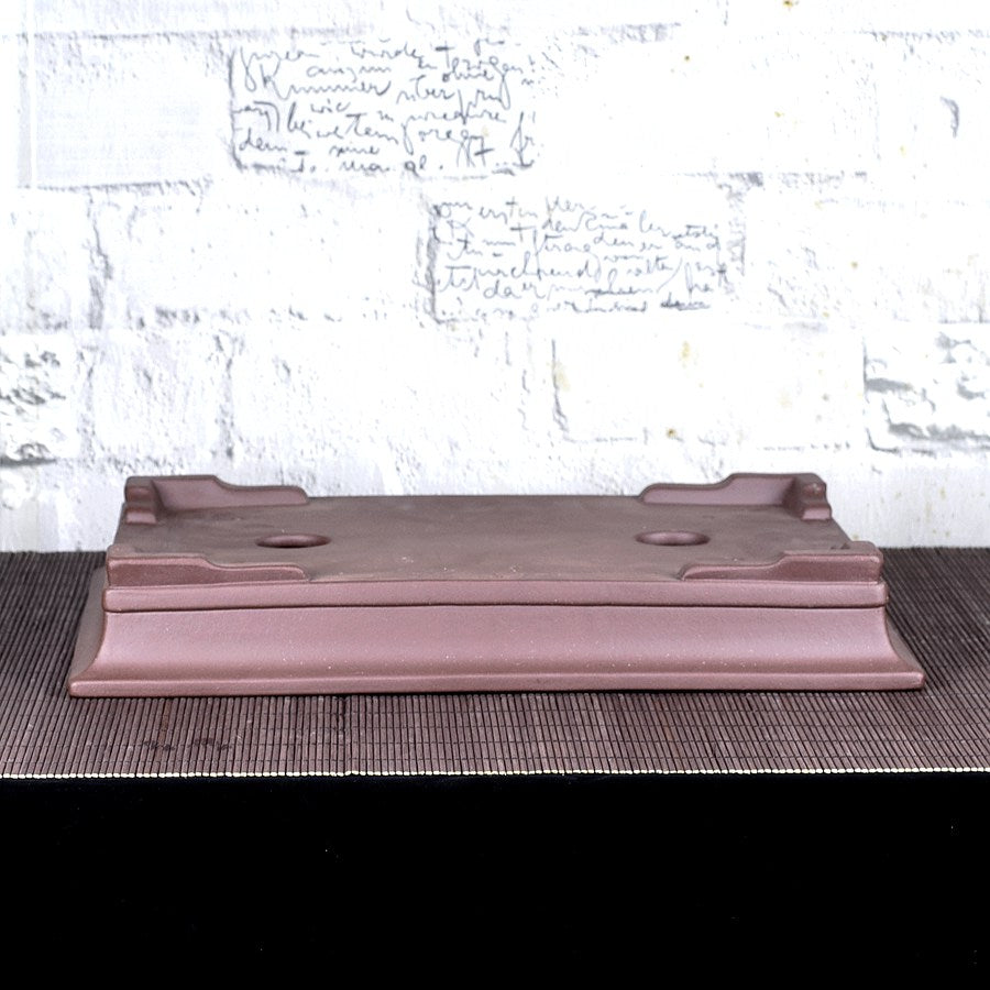 Upside-down brown rectangular pot showing low feet and flared base profile