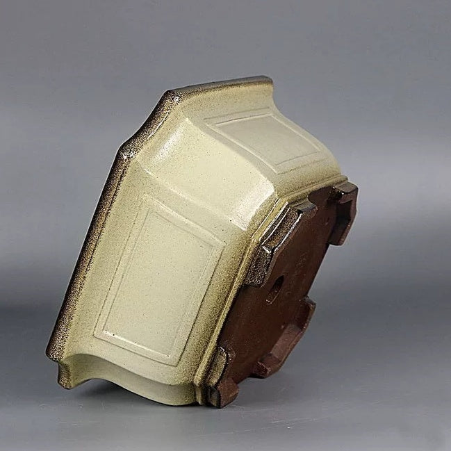 Tilted view of the cream square pot showing its glazed panel, base and short feet