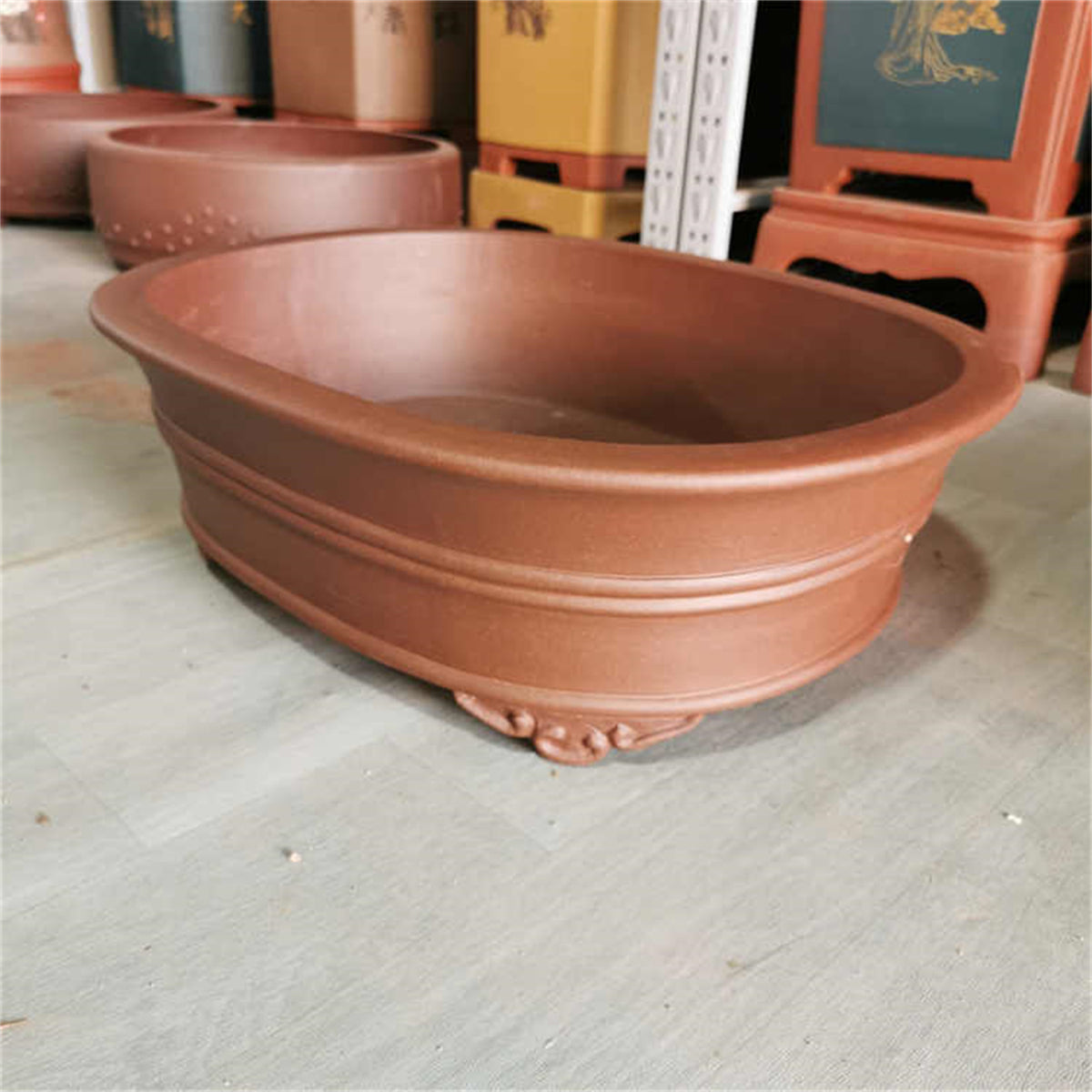 Angled brown oval pot showing double bands and curled feet