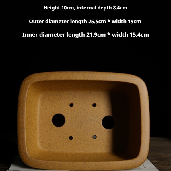 Interior of the ochre pot showing two drainage holes, four smaller openings and dimension labels