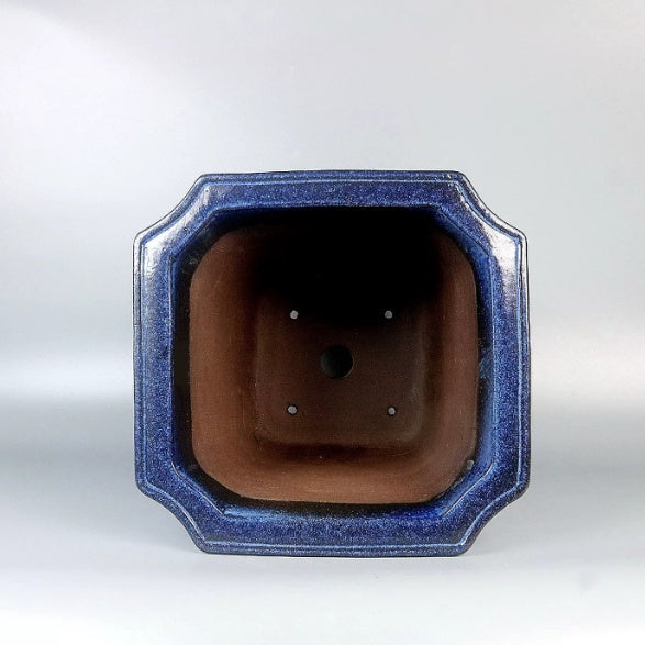 Top view of blue square pot showing brown interior and base openings
